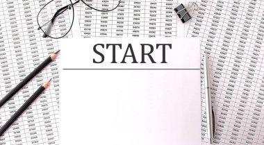 Tabloların üzerinde START olan kağıt