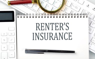 Not defterinde hesap makinesi ve klavye ile RENTER 'İN INSURANCE Metni