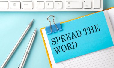 Kelime metnini mavi arkaplandaki çıkartmaya kalem ve klavye ile dağıt