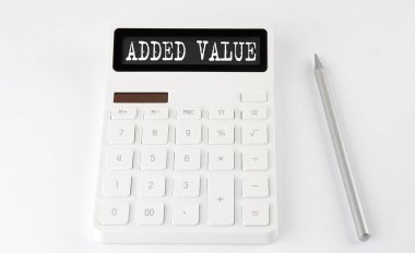 Hesap makinesinde kurşun kalemle birlikte ADDED VALUE iş metni