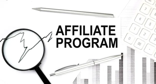 AFFILIATE PROGRAM text on the document with pen,graph and magnifier,calculator