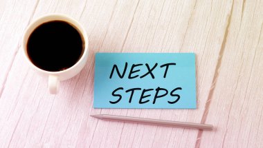 Mavi etiketli kahve ve kalemli NEXT STEPS metni