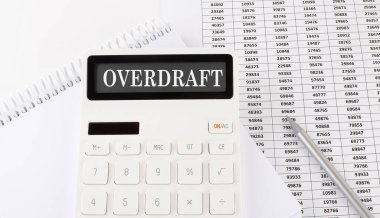 Defterde OVERDRAFT yazan bir hesap makinesi. İş, finans kavramsal.