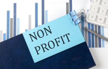 Çizelge arkaplanındaki not defterindeki yapışkan notta NON PROFIT