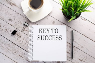 Kahve fincanı, not defteri, tahta arka planda kalem. İş konsepti. KAYIP 'A SMS anahtarı