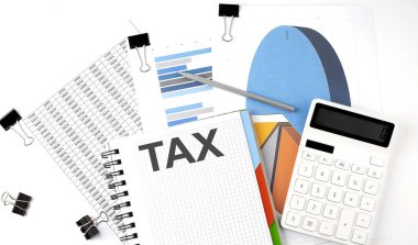 Hesap makinesi ve kalem ile şema ve grafikler üzerinde bir dizüstü bilgisayar üzerinde metin vergisi