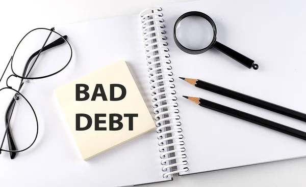 Slovo Bad Debt Podložce Notebooku Tužkami Lupou Brýlemi — Stock fotografie