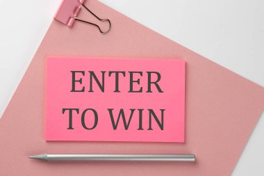 Pembe kağıda, beyaz arkaplandaki kalemle pembe etiket yapıştırılmış ve ENTER To WIN