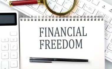 FİNANSIAL FREEDOM Metni hesap makinesi ve klavye ile not defterinde, iş