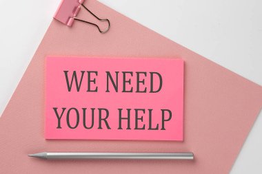 Pembe kağıt üzerine pembe etiket, beyaz arka planda kalem ve metin. Yardımınıza ihtiyacımız var.