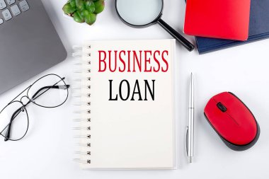 Not defterinde beyaz arka planda dizüstü bilgisayarı olan iş kredisi metni