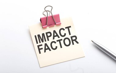 Beyaz arkaplandaki kalemle etiketteki IMPACT FACTOR metni