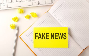 Ajandadaki klavye ve kalem etiketinin üzerindeki sahte haber metni