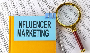 INFUENCER MİLKETING metin üzerine yapıştırma üzerine not büyüteç ve çizelge ile. İş dünyası