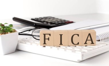 FICA, klavyede ofis araçlarıyla birlikte tahta bir küp üzerine yazılmış.