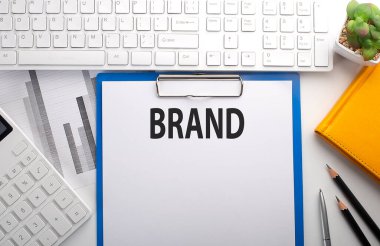 Klavye, çizelge, hesap makinesi ve defter ile kağıda yazılmış BRAND