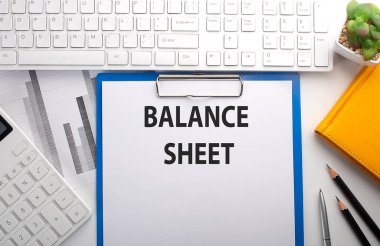 Klavye, çizelge, hesap makinesi ve defter ile kağıda yazılmış balans SHEET