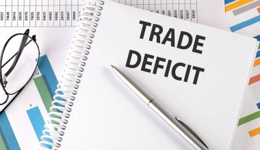 Çizelgede TRADE DEFICIT kalem ve gözlük, iş konsepti
