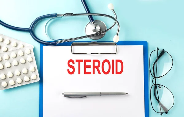 Papier Met Tekst Steroid Blauwe Achtergrond Met Stethoscoop Pillen — Stockfoto