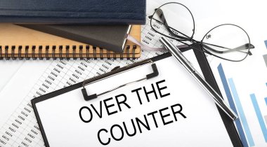 Ofis masasındaki masada, beyaz arkaplanda not defterleri, malzemeler, analiz çizelgesi olan metin..