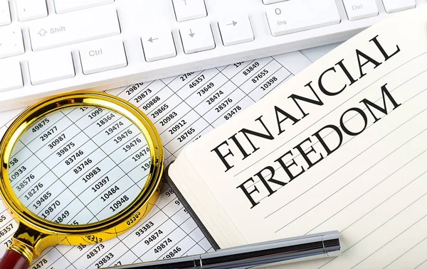 FİNANSIAL FREEDOM metin üzerinde grafik, büyüteç, klavye ve kalem