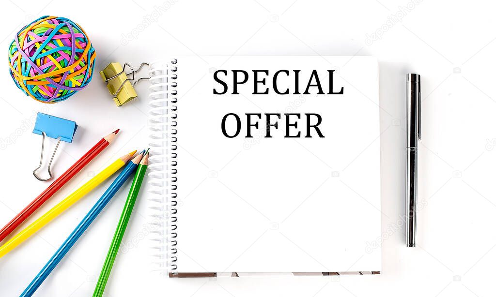 Notebook ,pencils,pen and rubber band with text SPECIAL OFFER on white background