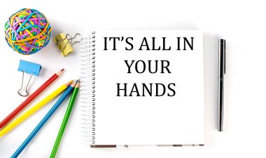 Not defteri, kalemler, kalem ve lastik bant hepsi senin ellerinde, beyaz arkaplanda.