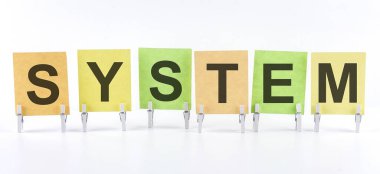 SYSTEM ifadesi beyaz arkaplanda çok renkli çıkartmalara yazılmıştır. İş kavramı, strateji, planlama.