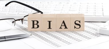 Klavye, hesap makinesi, çizelge ve gözlüklerle ahşap küpte yazılı BIAS. İş dünyası