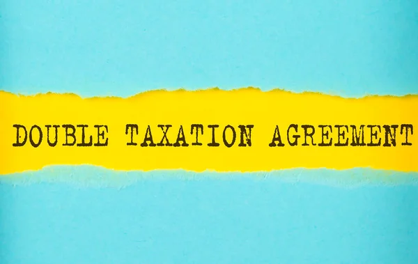 Double Taxatie Overeenkomst Tekst Gescheurd Papier Gele Achtergrond — Stockfoto
