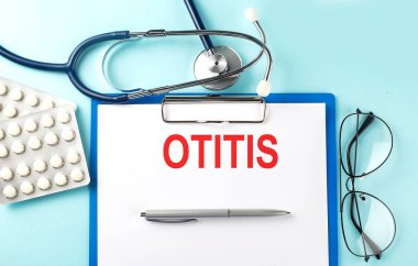 Stetoskop ve haplarla mavi arka planda metin OTITIS kağıdı