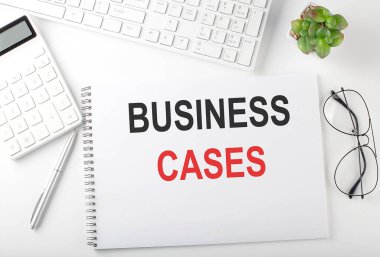 Klavyesi, not defteri ve hesap makinesi olan bir ofis masası. Üst görünüm, metin BÜYÜK CASES