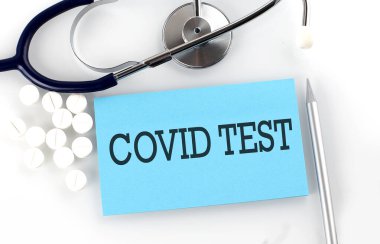 Steteskop, hap, kalem ve tıbbi konsept içeren metin COVID testi.