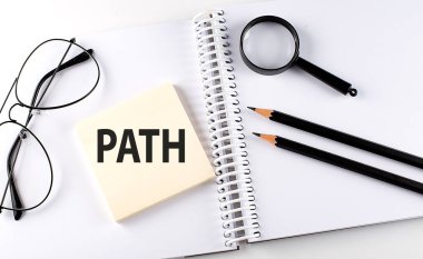 Not defterindeki hasta üzerinde kalem, büyüteç ve gözlüklü Kelime PATH