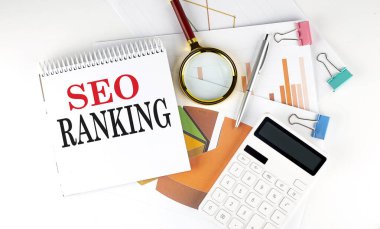 Beyaz not defteri beyaz arkaplan üzerinde şema, grafik, hesap makinesi olan SEO RANking