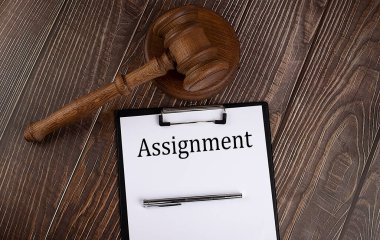 Etiketteki ASSIGNMENT metni beyaz arkaplanda kalemle