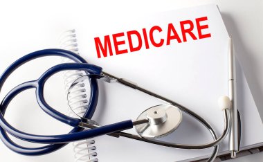 Notebook with text MEDICARE with pen and stethoscope, medicina