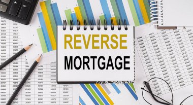 Closeup a notebook with text REVERSE MORTGAGE , business concept image on the chart background