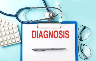Paper with text DIAGNOSIS on blue background with stethoscope and pills