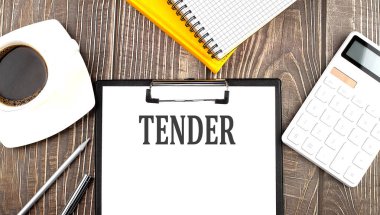 TENDER text on paper with coffee, calculator and notebook. Business