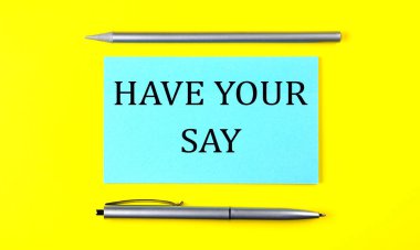 text HAVE YOUR SAY on blue sticker on the yellow background