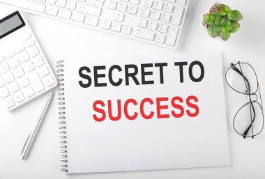 Office desk table with keyboard, notepad and calculator. Top view, text SECRET TO SUCCESS