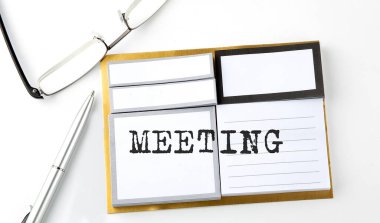 MEETING text on sticky notes with glasses and pen, business concept