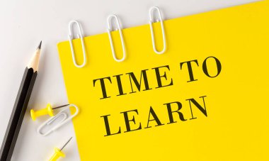 TIME TO LEARN word on yellow paper with office tools on the white background