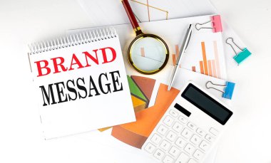 White notepad text BRAND MESSAGE with diagram,chart,calculator on the white background