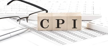 CPI written on wooden cube with keyboard , calculator, chart,glasses.Business