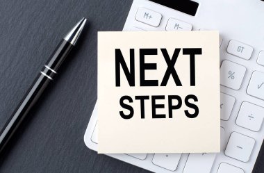 Hesap makinesindeki etiket üzerinde NEXT STEPS metni, iş konsepti