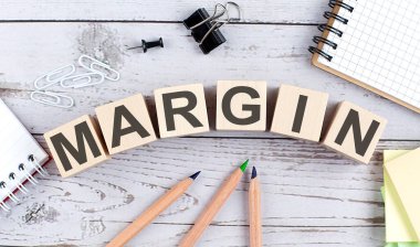 Ahşap bloktaki MARGIN metni ve ahşap arkaplanda ofis araçları
