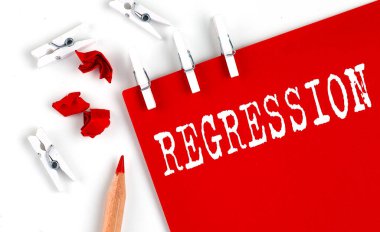 Beyaz arkaplanda ofis araçları ile kırmızı kağıt üzerinde REGRESSION metin