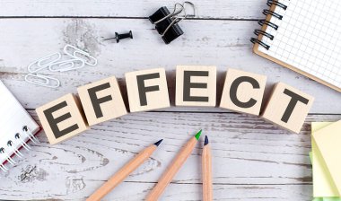 Tahta blokta efekt metni ve ahşap arka planda ofis araçları